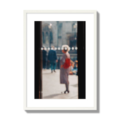 Fine art photograph of a blurred street scene with people and a storefront, archival pigment print, large size, white frame.