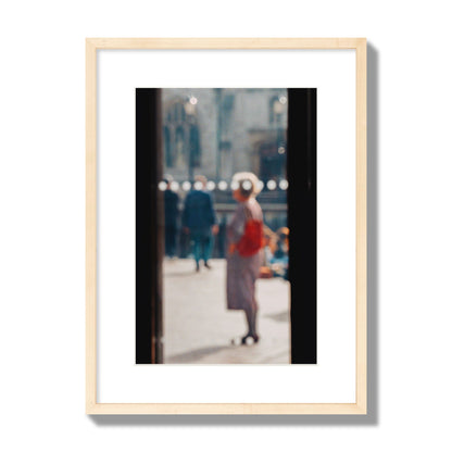 Fine art photograph of a blurred street scene with people and a storefront, archival pigment print, medium size, natural wood frame.