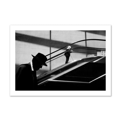 Fine art black and white street photograph of a man ascending an escalator. Archival pigment print, collector size, print.