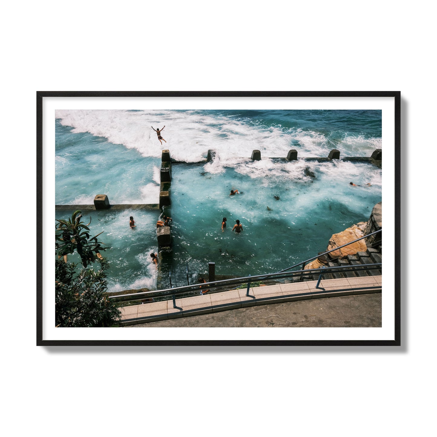 Fine art street photograph of a man jumping into the ocean. Archival pigment print, collector size, black frame.