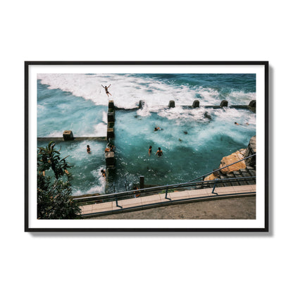 Fine art street photograph of a man jumping into the ocean. Archival pigment print, collector size, black frame.