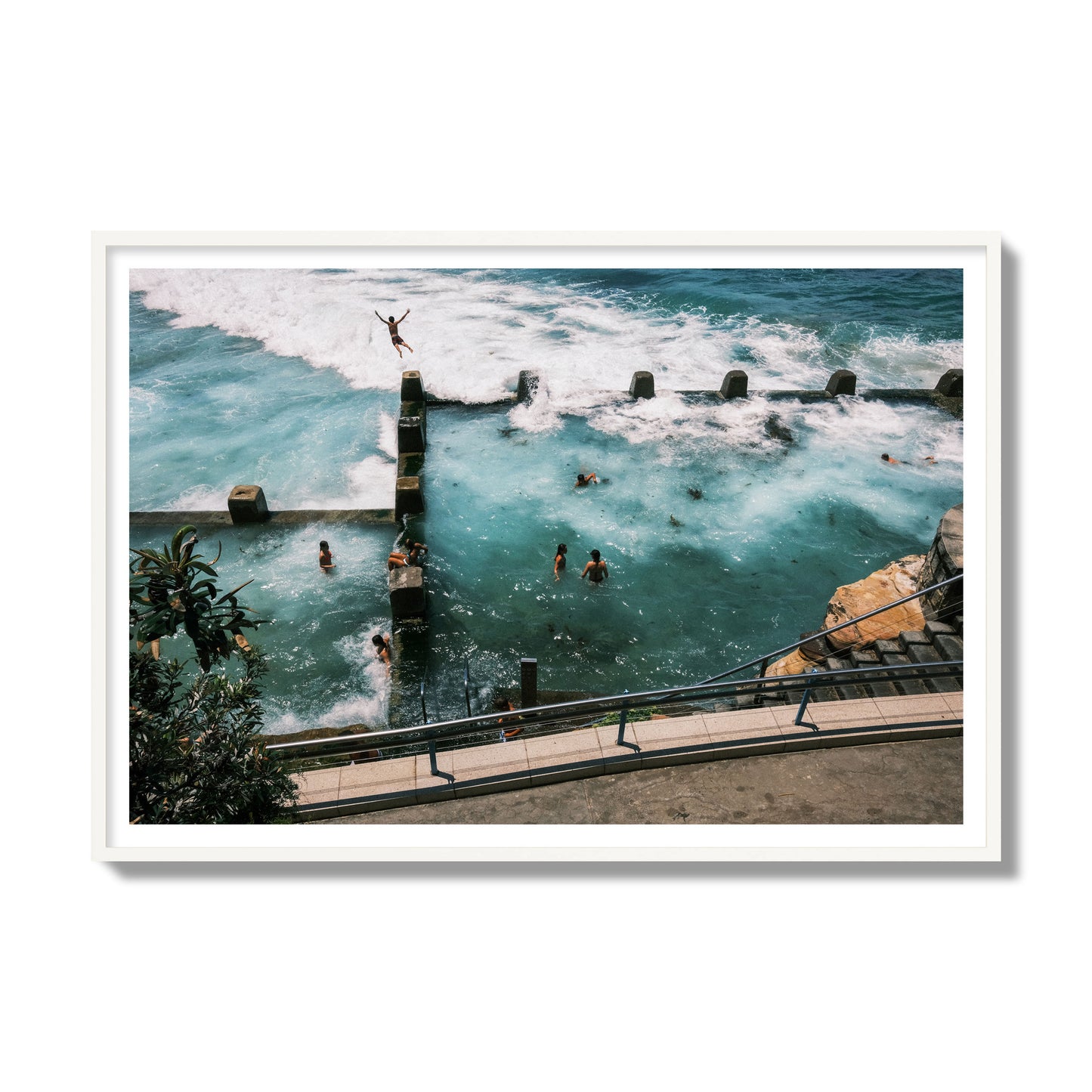 Fine art street photograph of a man jumping into the ocean. Archival pigment print, gallery size, white frame.