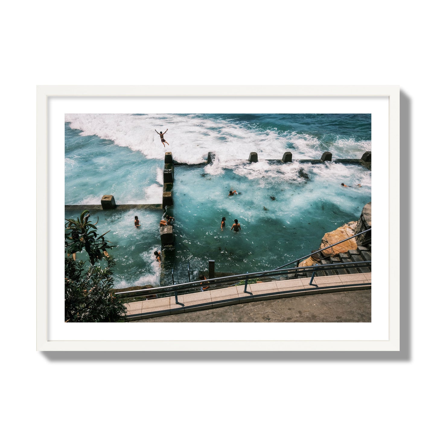 Fine art street photograph of a man jumping into the ocean. Archival pigment print, giant size, white frame.