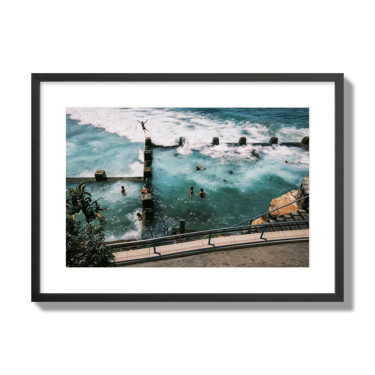 Fine art street photograph of a man jumping into the ocean. Archival pigment print, large size, black frame.