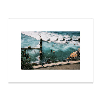Fine art street photograph of a man jumping into the ocean. Archival pigment print, small size, print.