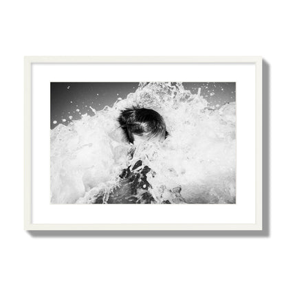 Fine art street photograph of an ocean wave crashing over a swimmer. Archival pigment print, large size, white frame.