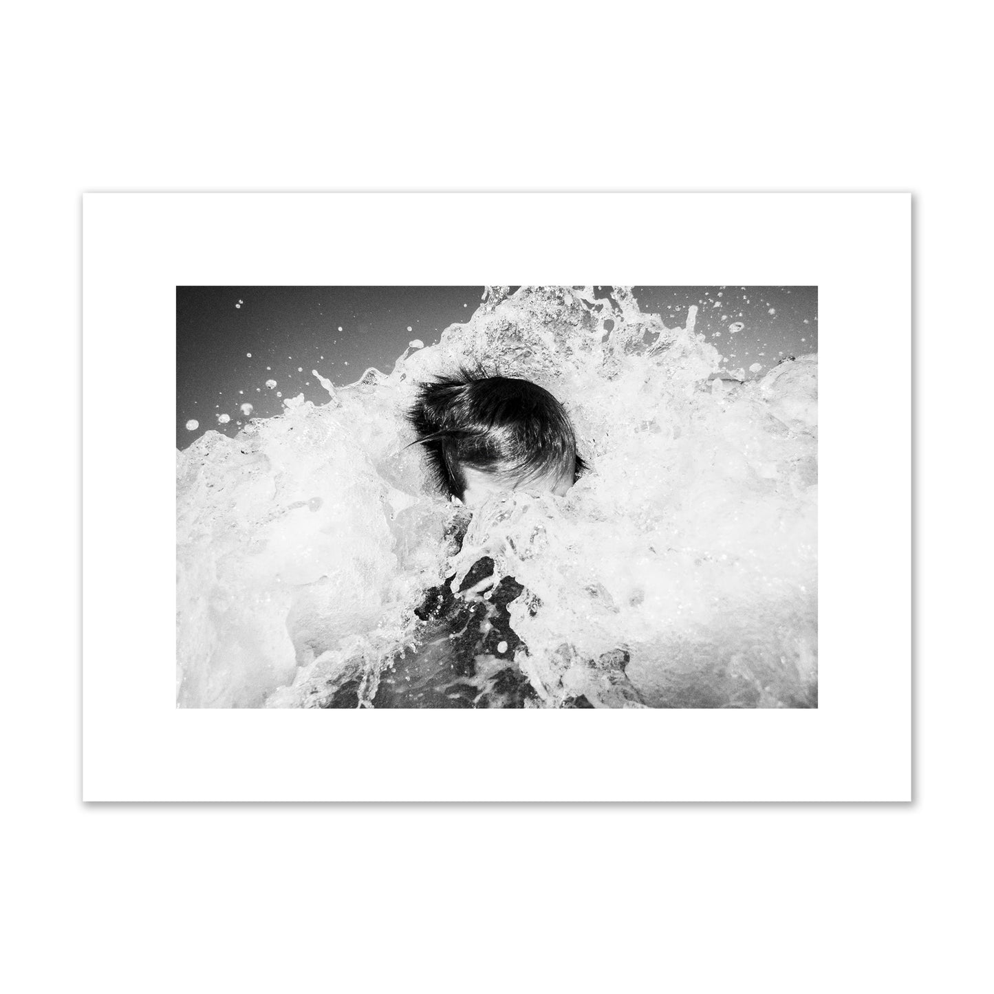 Fine art street photograph of an ocean wave crashing over a swimmer. Archival pigment print, medium size, print.