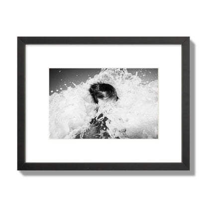 Fine art street photograph of an ocean wave crashing over a swimmer. Archival pigment print, small size, black frame.