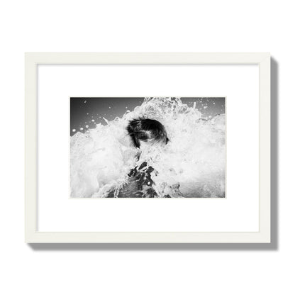 Fine art street photograph of an ocean wave crashing over a swimmer. Archival pigment print, small size, white frame.