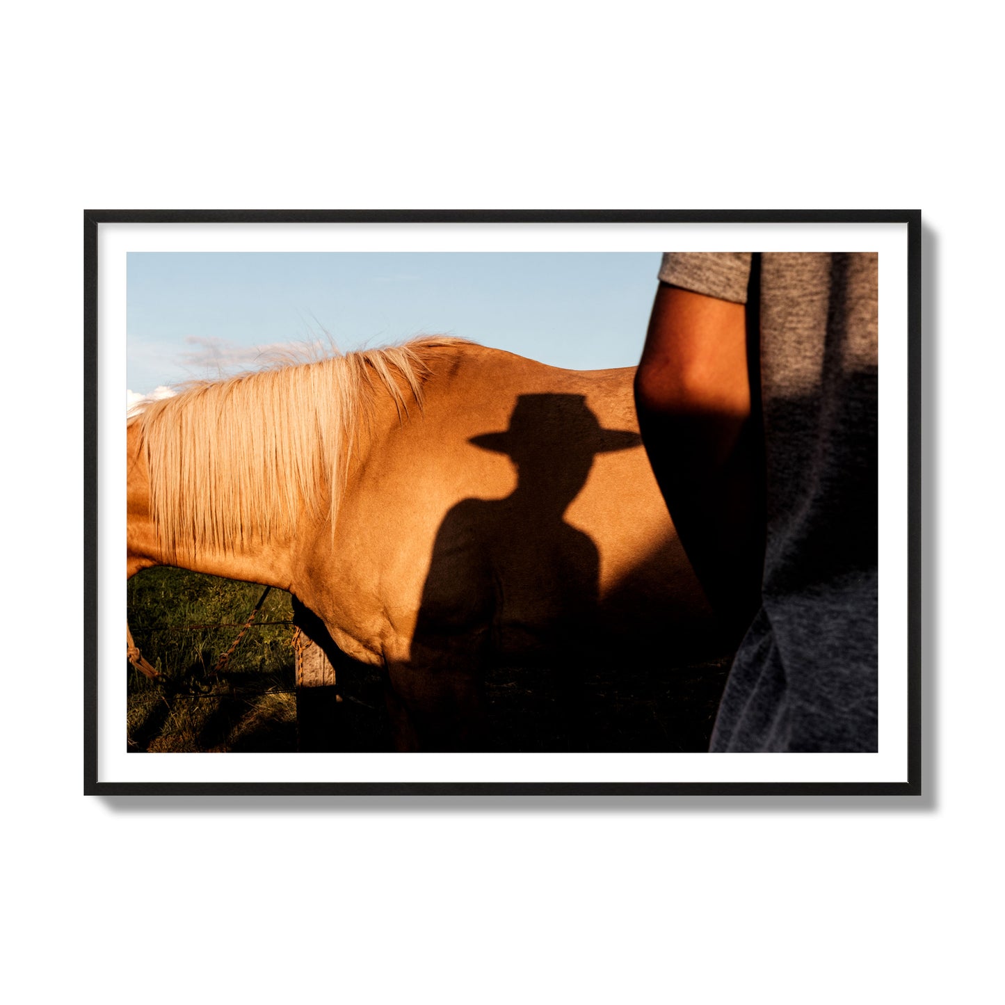 Fine art photo of a cowboy's shadow cast against the side of a horse at sunset. Archival pigment print, collector size, black frame.