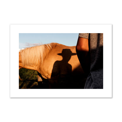 Fine art photo of a cowboy's shadow cast against the side of a horse at sunset. Archival pigment print, giant size, print.