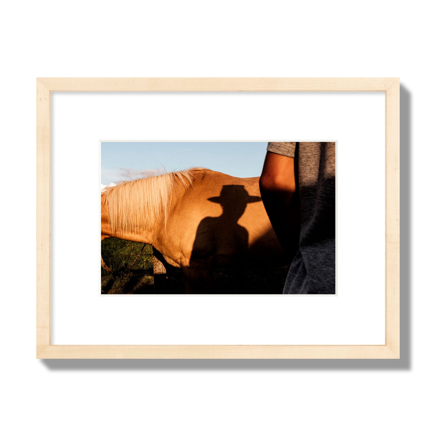 Fine art photo of a cowboy's shadow cast against the side of a horse at sunset. Archival pigment print, small size, natural wood frame.