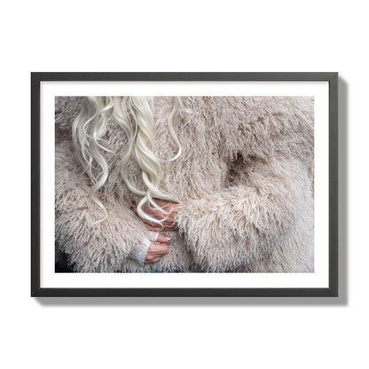 Fine art  street photograph of a woman wrapped in a huge furry coat. Archival pigment print, giant size, black frame.