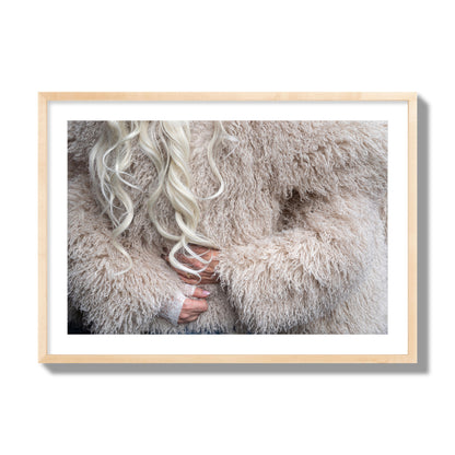 Fine art  street photograph of a woman wrapped in a huge furry coat. Archival pigment print, giant size, natural wood frame.