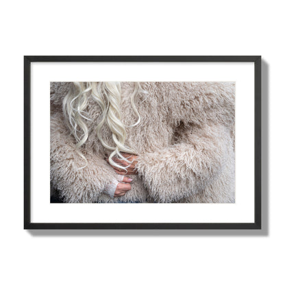 Fine art  street photograph of a woman wrapped in a huge furry coat. Archival pigment print, large size, black frame.