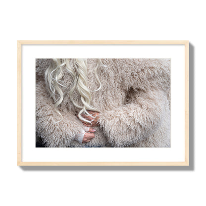 Fine art  street photograph of a woman wrapped in a huge furry coat. Archival pigment print, large size, natural wood frame.