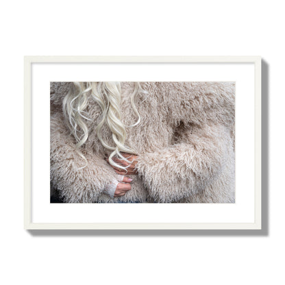 Fine art  street photograph of a woman wrapped in a huge furry coat. Archival pigment print, large size, white frame.