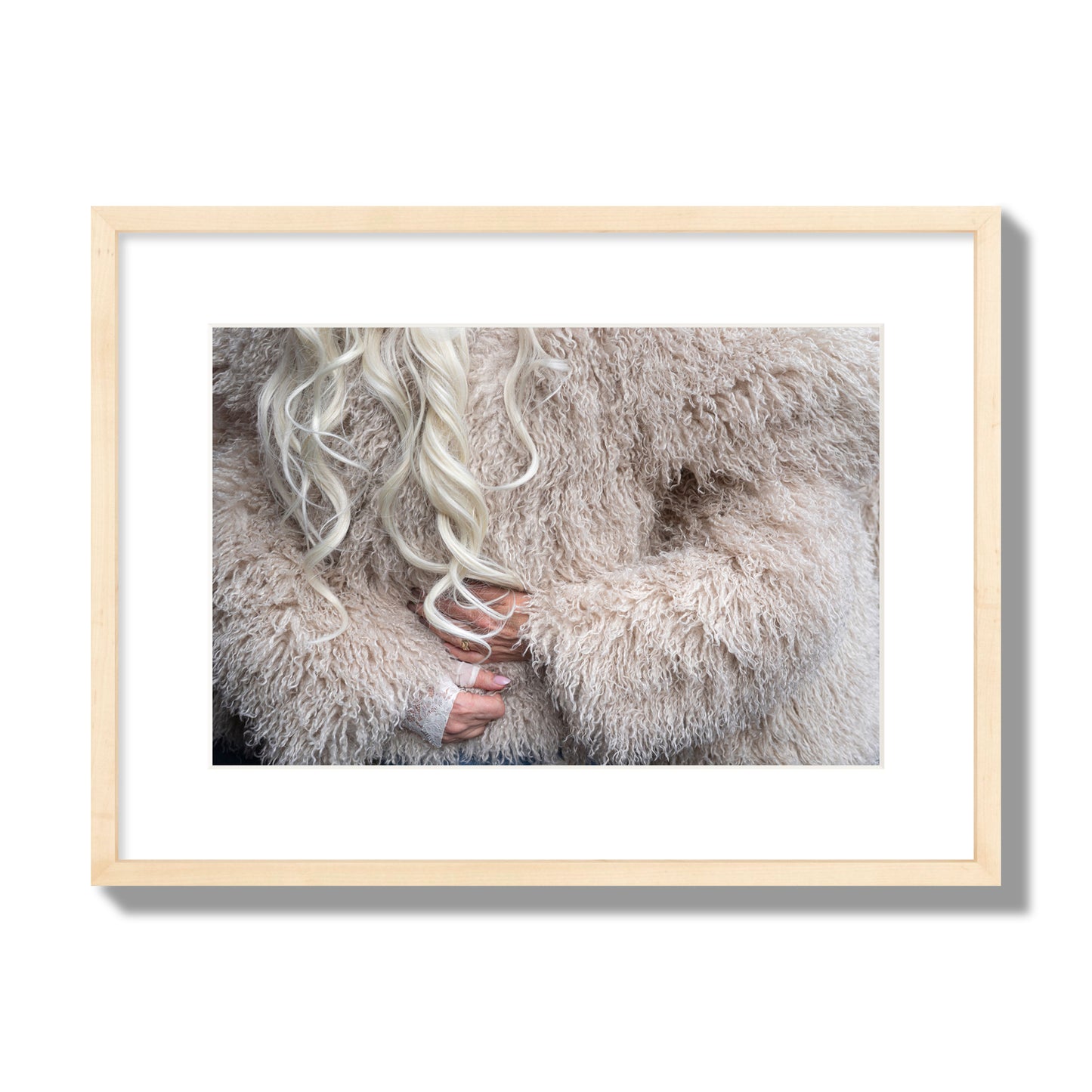 Fine art  street photograph of a woman wrapped in a huge furry coat. Archival pigment print, medium size, natural wood frame.