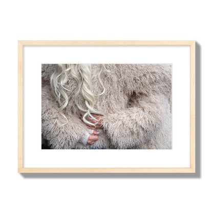 Fine art  street photograph of a woman wrapped in a huge furry coat. Archival pigment print, medium size, natural wood frame.
