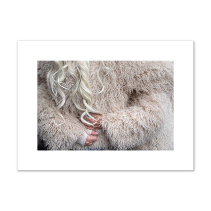 Fine art  street photograph of a woman wrapped in a huge furry coat. Archival pigment print, medium size, print.