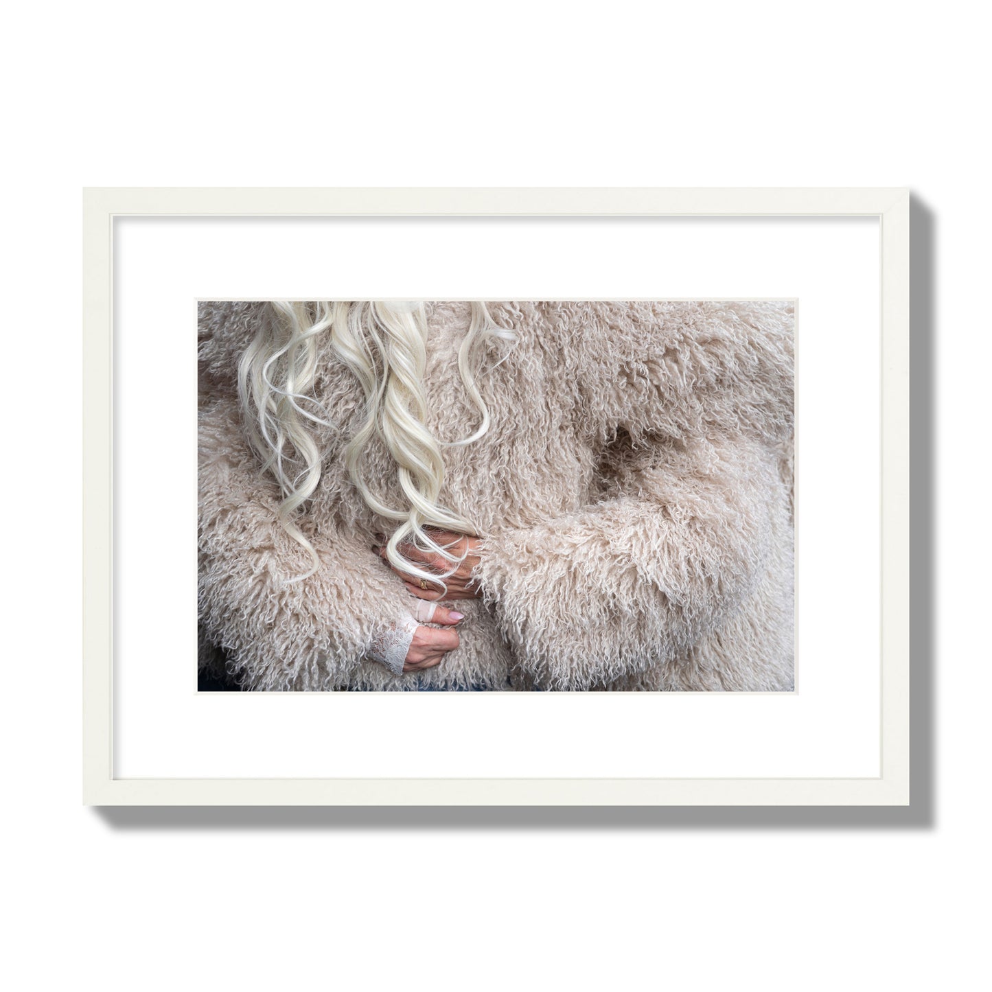 Fine art  street photograph of a woman wrapped in a huge furry coat. Archival pigment print, medium size, white frame.