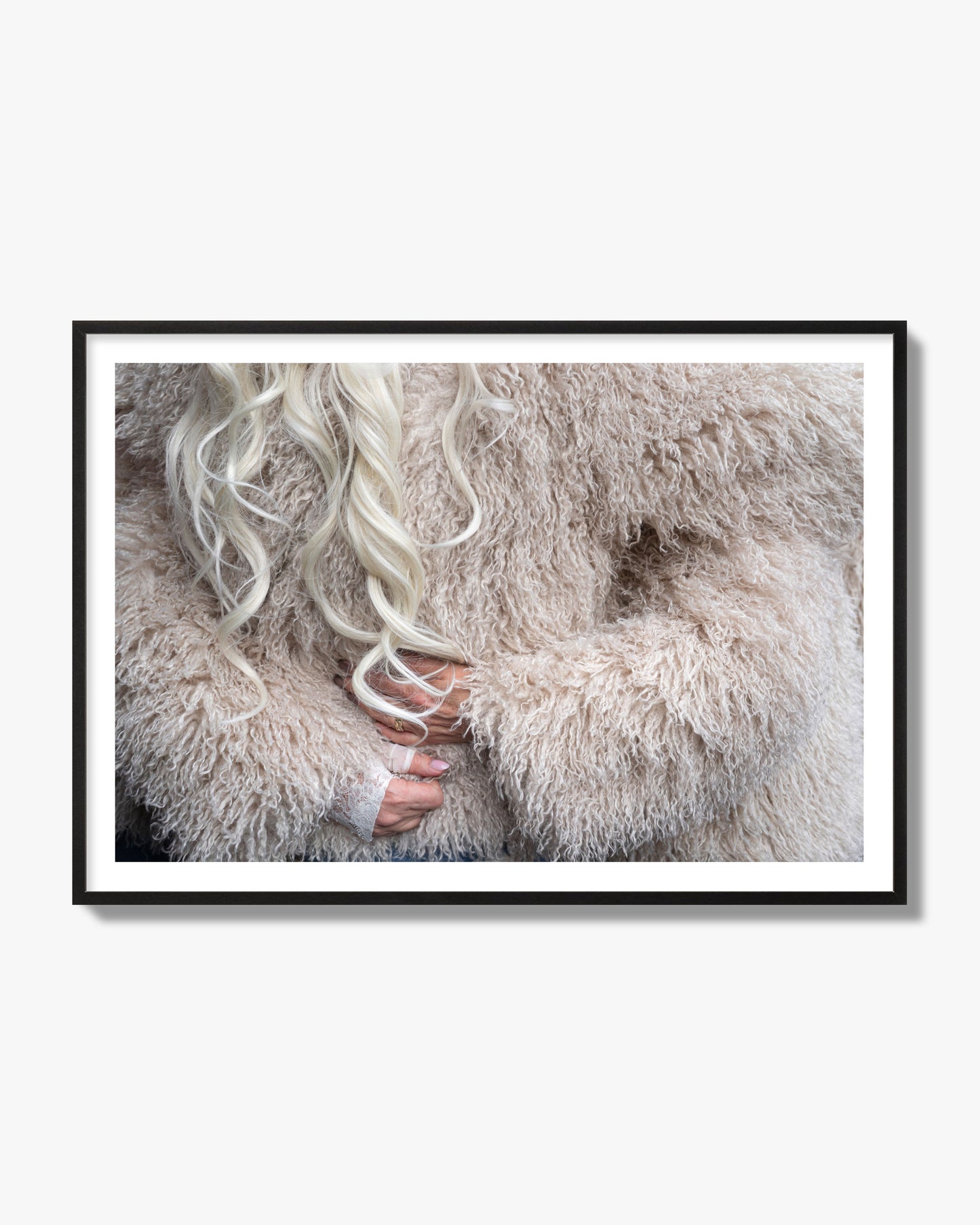Fine art  street photograph of a woman wrapped in a huge furry coat. Archival pigment print, black frame.
