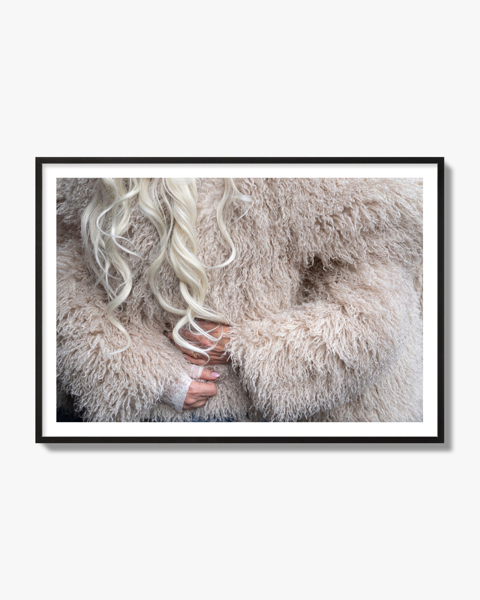 Fine art  street photograph of a woman wrapped in a huge furry coat. Archival pigment print, black frame.