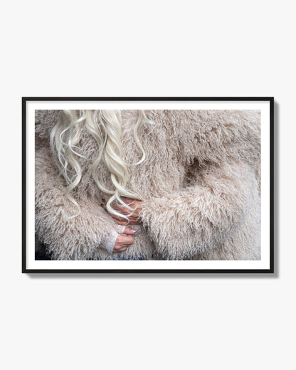 Fine art  street photograph of a woman wrapped in a huge furry coat. Archival pigment print, black frame.