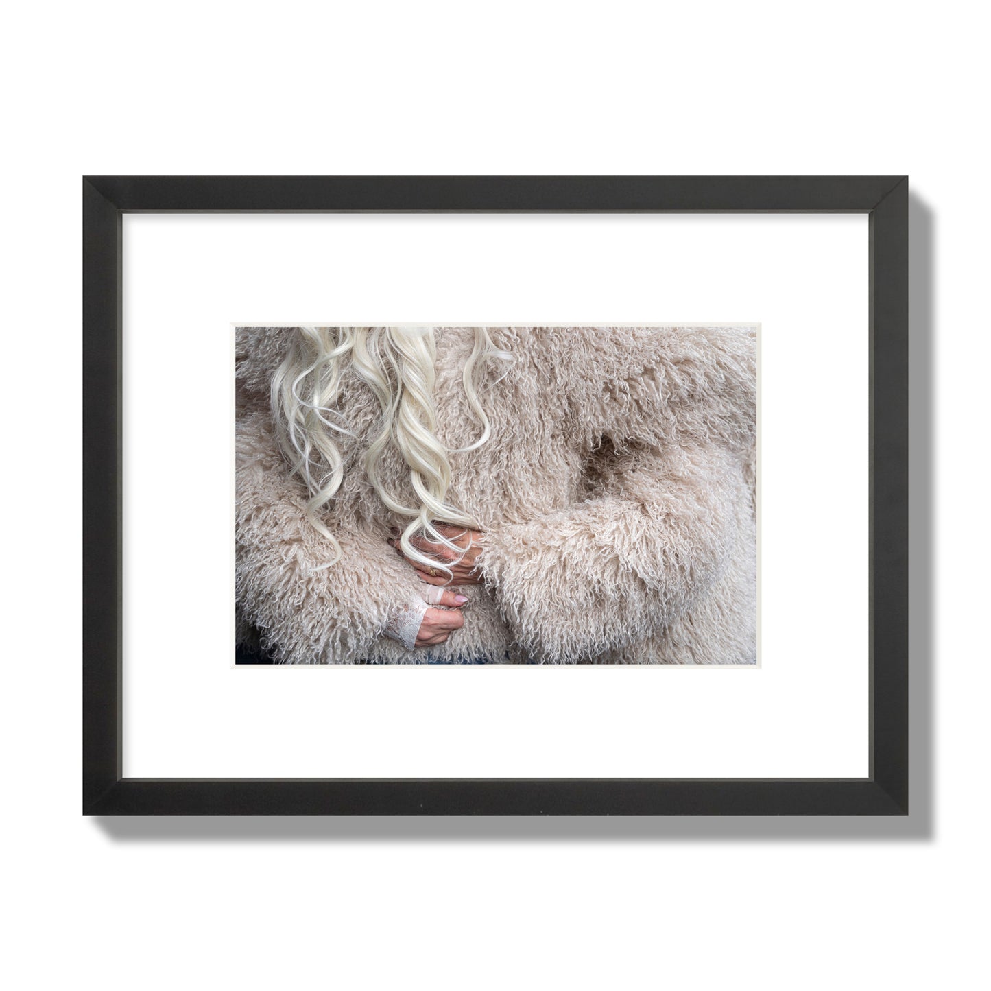 Fine art  street photograph of a woman wrapped in a huge furry coat. Archival pigment print, small size, black frame.