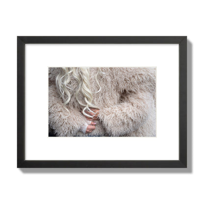 Fine art  street photograph of a woman wrapped in a huge furry coat. Archival pigment print, small size, black frame.