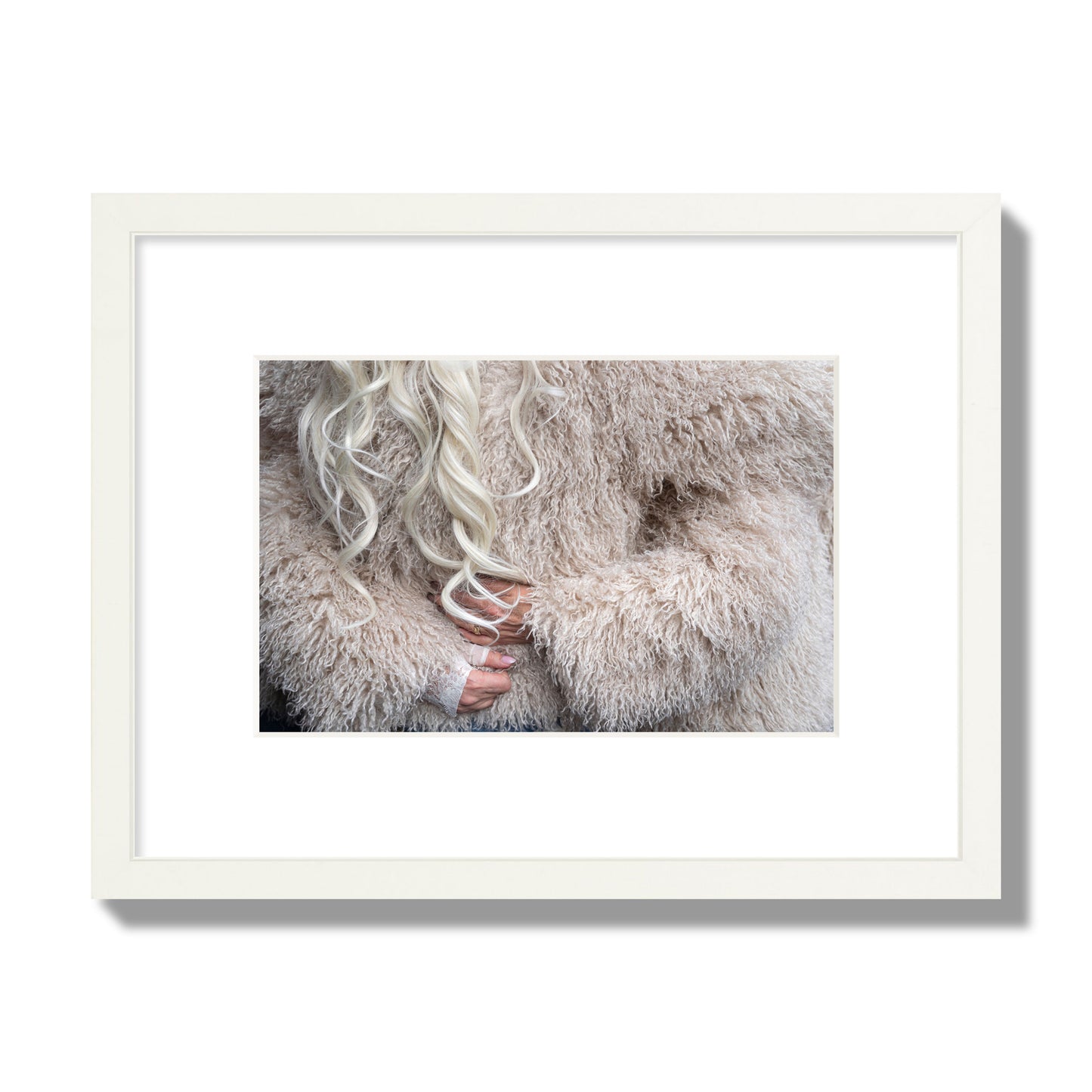 Fine art  street photograph of a woman wrapped in a huge furry coat. Archival pigment print, small size, white frame.