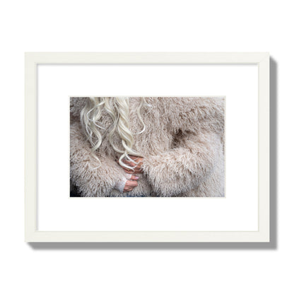 Fine art  street photograph of a woman wrapped in a huge furry coat. Archival pigment print, small size, white frame.