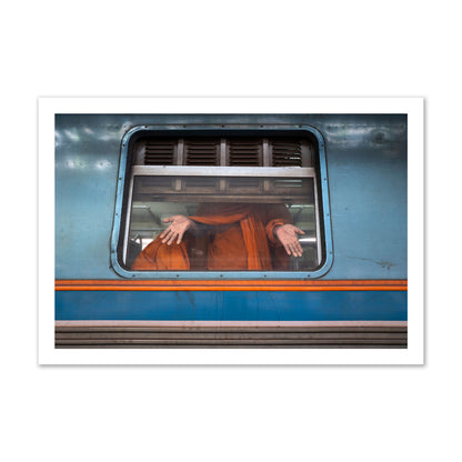 Fine art photograph of a Buddhist monk standing with open hands at a train car window. Archival pigment print, gallery size, print.