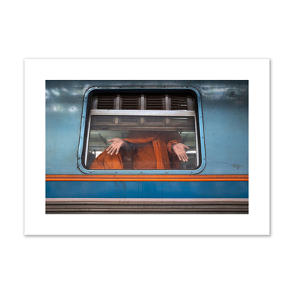 Fine art photograph of a Buddhist monk standing with open hands at a train car window. Archival pigment print, giant size, print.