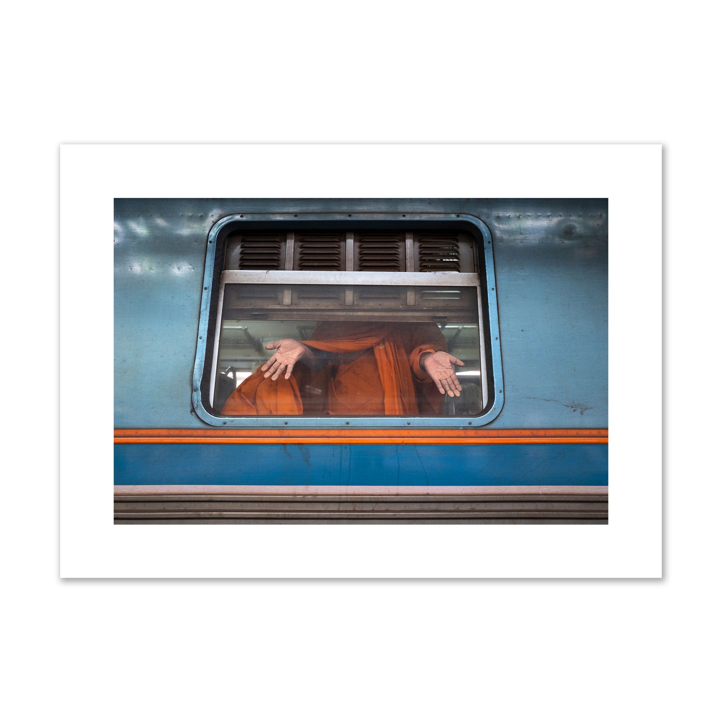 Fine art photograph of a Buddhist monk standing with open hands at a train car window. Archival pigment print, large size, print.