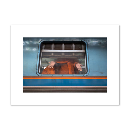 Fine art photograph of a Buddhist monk standing with open hands at a train car window. Archival pigment print, medium size, print.