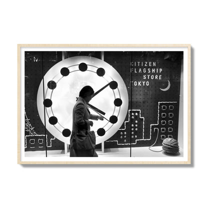 Fine art street photograph of a woman checking her watch as she walks past a giant clock on a busy Tokyo city street. Archival pigment print, gallery size, natural wood frame.