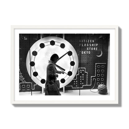 Fine art street photograph of a woman checking her watch as she walks past a giant clock on a busy Tokyo city street. Archival pigment print, giant size, white frame.