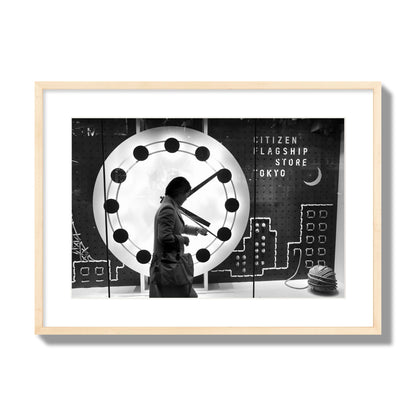 Fine art street photograph of a woman checking her watch as she walks past a giant clock on a busy Tokyo city street. Archival pigment print, large size, natural wood frame.