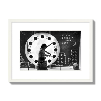 Fine art street photograph of a woman checking her watch as she walks past a giant clock on a busy Tokyo city street. Archival pigment print, medium size, white frame.
