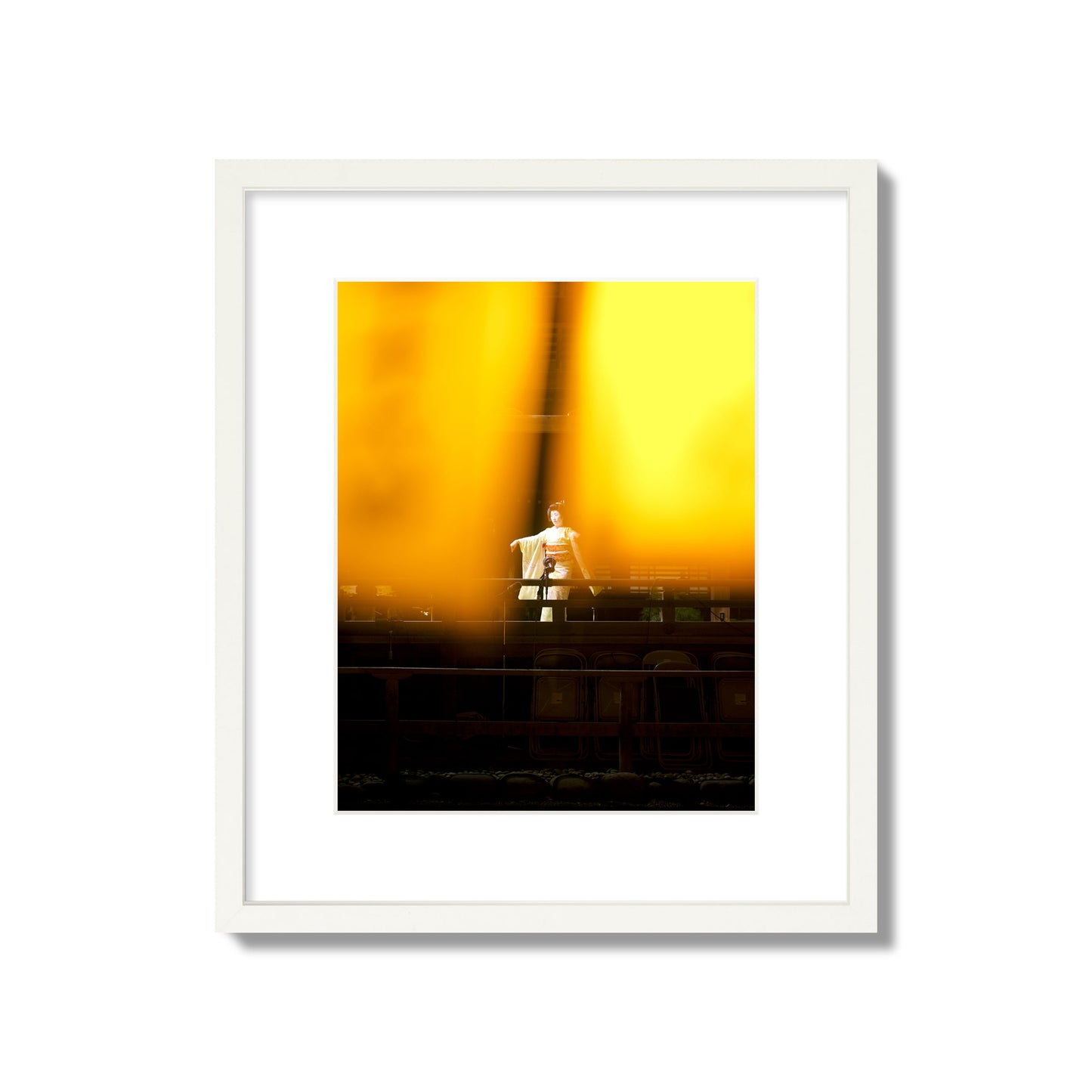 Fine art photograph of a geisha dancing, photographed through yellow lanterns, archival pigment print, medium size, white frame.