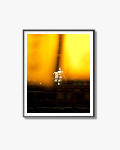 Fine art photograph of a geisha dancing, photographed through yellow lanterns, archival pigment print, black frame.