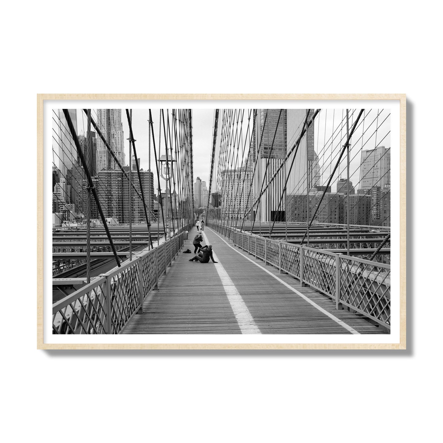 Fine art black and white photograph of a person posing on the Brooklyn Bridge with the cityscape in the background, archival pigment print, gallery size, natural wood frame