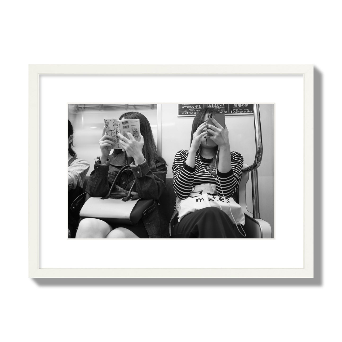 Black and white fine art photograph of two women on the Tokyo Metro, archival pigment print, medium size, white frame