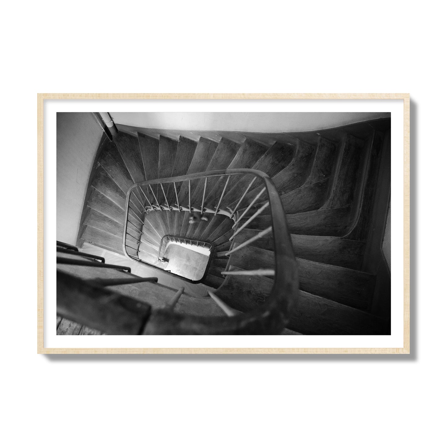 Fine art street photograph of a person walking down a staircase in Paris, France, archival pigment print, collector size, natural wood frame