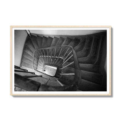 Fine art street photograph of a person walking down a staircase in Paris, France, archival pigment print, gallery size, natural wood frame