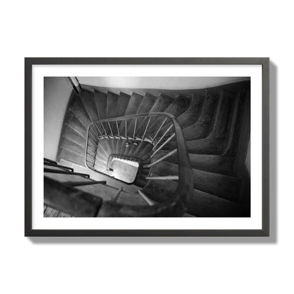 Fine art street photograph of a person walking down a staircase in Paris, France, archival pigment print, giant size, black frame