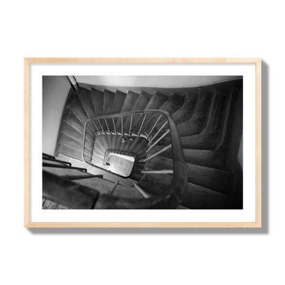 Fine art street photograph of a person walking down a staircase in Paris, France, archival pigment print, giant size, natural wood frame