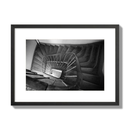 Fine art street photograph of a person walking down a staircase in Paris, France, archival pigment print, medium size, black frame