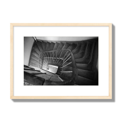 Fine art street photograph of a person walking down a staircase in Paris, France, archival pigment print, medium size, natural wood frame